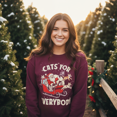 Woman wearing a maroon sweatshirt with a Christmas-themed design in a snowy outdoor setting